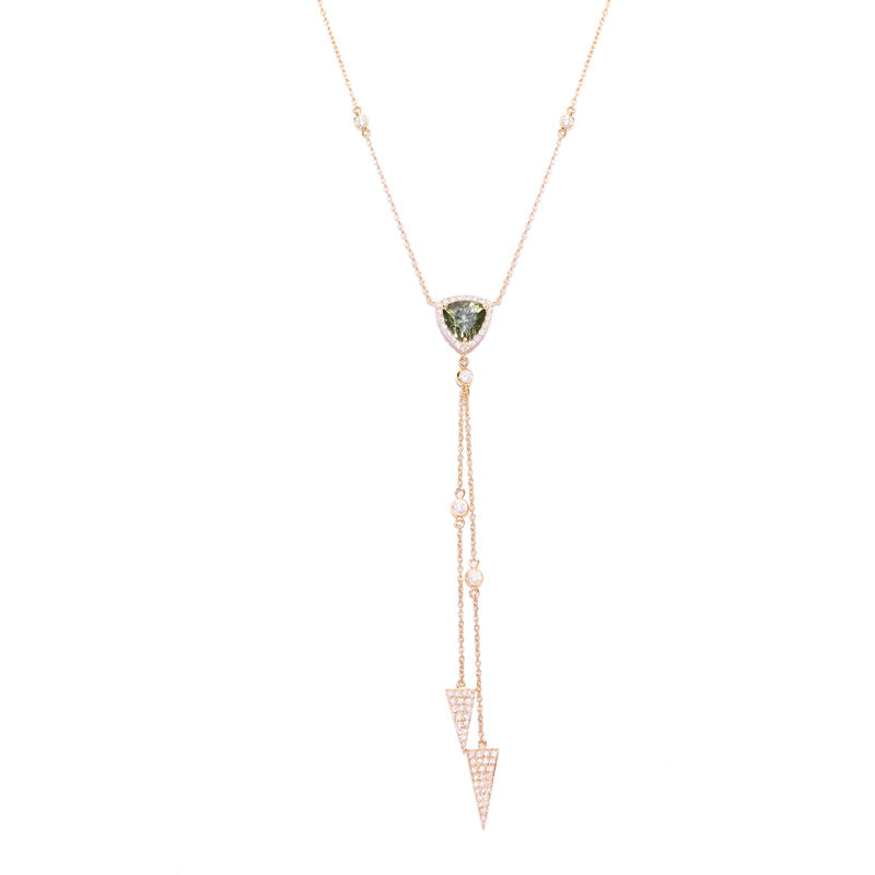 A green heart shaped tourmaline surrounded by white pavé-set diamonds. Embellished with yellow gold chains dangling with triangle shaped amulets. Entirely handcrafted and sits at the neckline with finesse.  Estimated Diamond Weight: 0.67 carat of diamond  Estimated Colored Stone Weight: 0.97 carat of tourmaline  Gold Weight: 18k Yellow gold