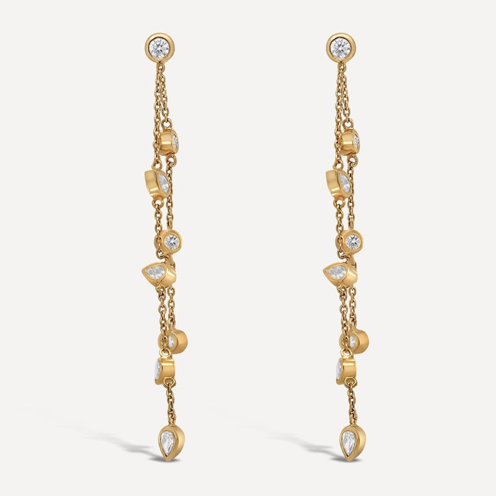Leila Issam's reinvention of a classic stud and chain earring; this detachable set of white diamond earrings can be worn as studs, or extended as jacket earrings set in yellow gold chains embellished with pear-cut white diamond bezel and round-cut white diamond bezel. For a signature twist, wear these stunning embellishments in asymmetry with the full set of stud and jacket earrings on one side.  Estimated Diamond Weight: 1.26 carat of diamond  Gold Weight: 18k Yellow gold