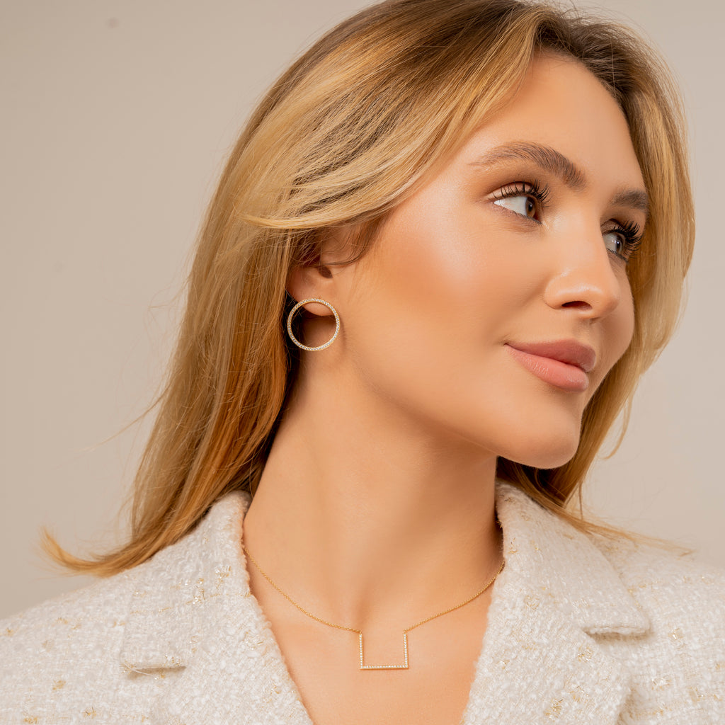 Leila Issma's signature pavé-set white diamond hoops in yellow gold. The elegant twist: small hoop earring posts are placed in an angle allowing the hoops to sit perfectly front viewed on any face shape.  Estimated Diamond Weight: 0.75 Carat of Diamond  Gold Weight: 18K Yellow Gold